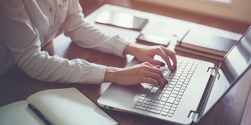 image of hands typing on a laptop keyboard.